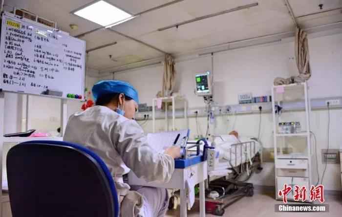 资料图:山西医科大学第一医院神外重症监护室(NICU)中,责任护士正在埋头奋笔疾书。王明宇 摄  天使,节日快乐!
