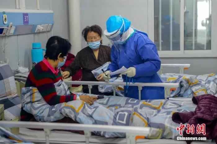 资料图:武汉火神山医院感染二科一病区的隔离病房内护士长胡晶为患者进行身体检查。中新社记者 张畅 摄  天使,节日快乐!