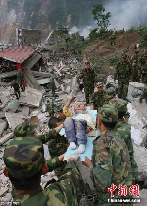 2008年5月13日,3岁的郎铮躺在担架上向解放军战士敬礼。杨卫华 摄 图片来源:视觉中国  汶川地震十二年:遥忆悲伤,记住灾难中不屈的精神
