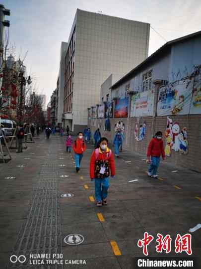 乌鲁木齐市第一小学开学第一天,学生走在校园门口的路上。 梁莉 摄  新疆中小学和中职学校全面开学复课